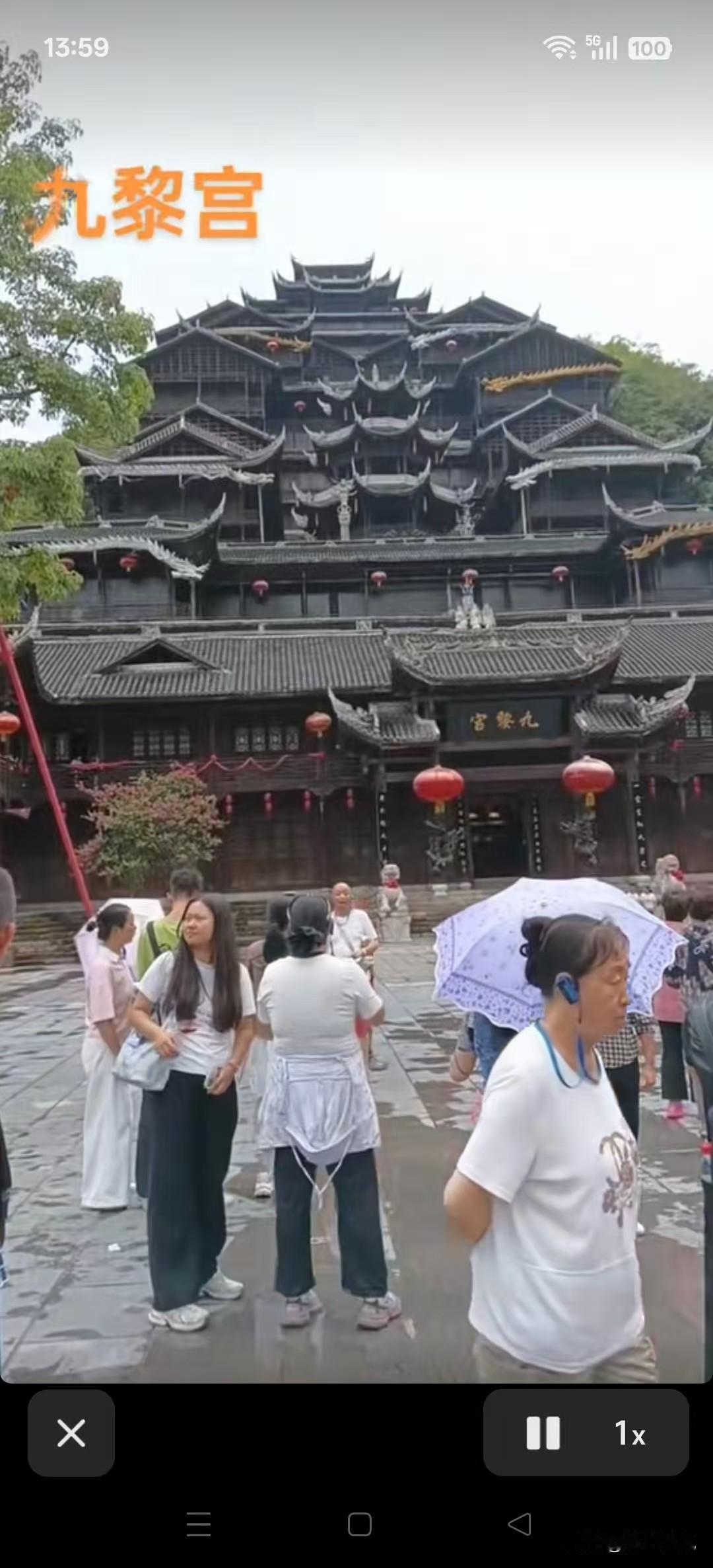 九黎宫的古典韵味，游客们撑伞漫步，感受历史与现代的交融。