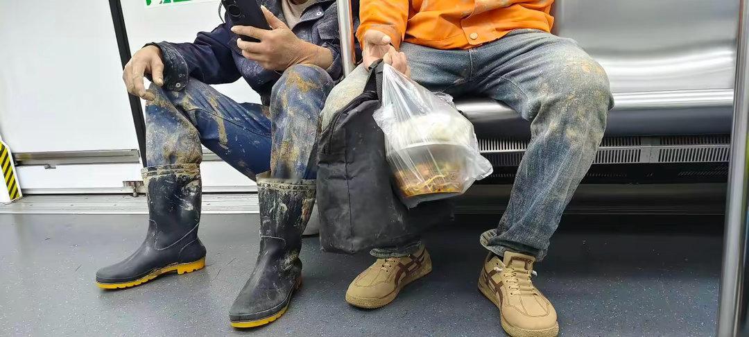 这才是最可爱的人从西湖文化广场上来两位浑身沾满泥土的农民工。这时的车厢内，几乎有