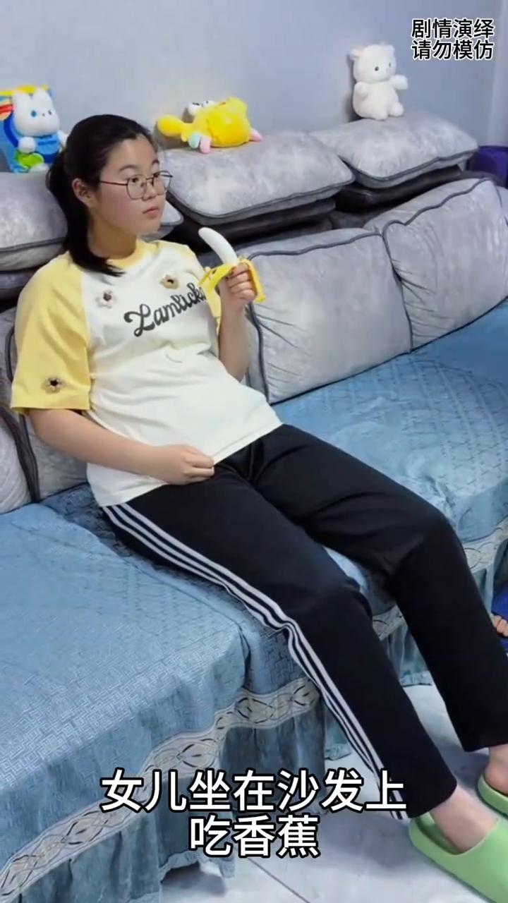 女儿整蛊爸爸吃到了假香蕉，这一幕真的太搞笑了。
女儿坐在沙发上吃香蕉，这时爸爸看