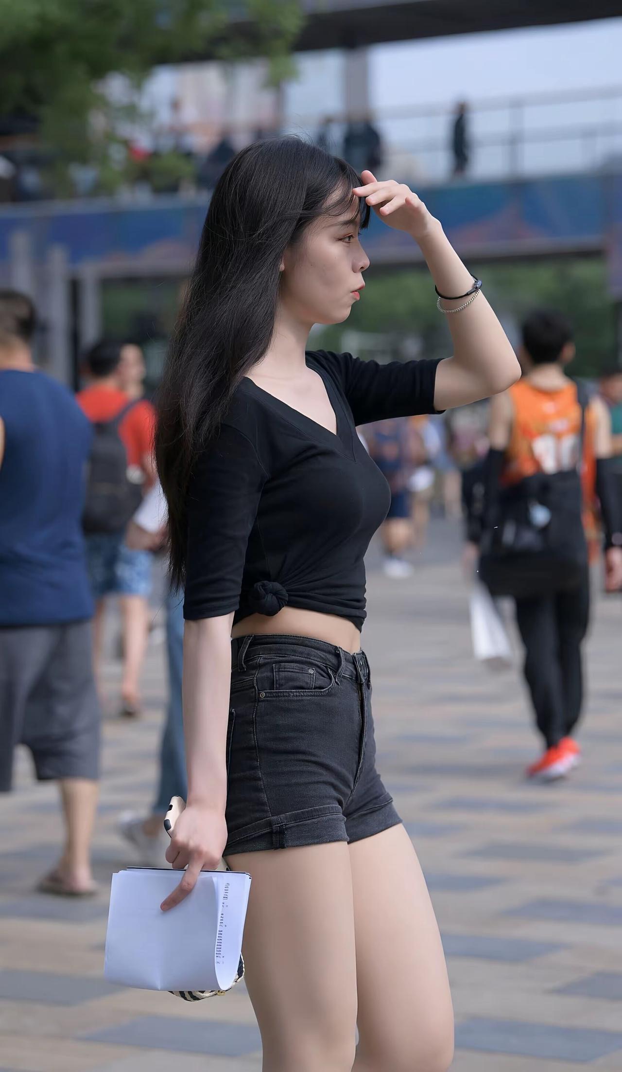 都市街头时尚少女，黑衣短裤，手拿小包，轻松自在。分享随手拍下的花朵 晒晒你拍的那