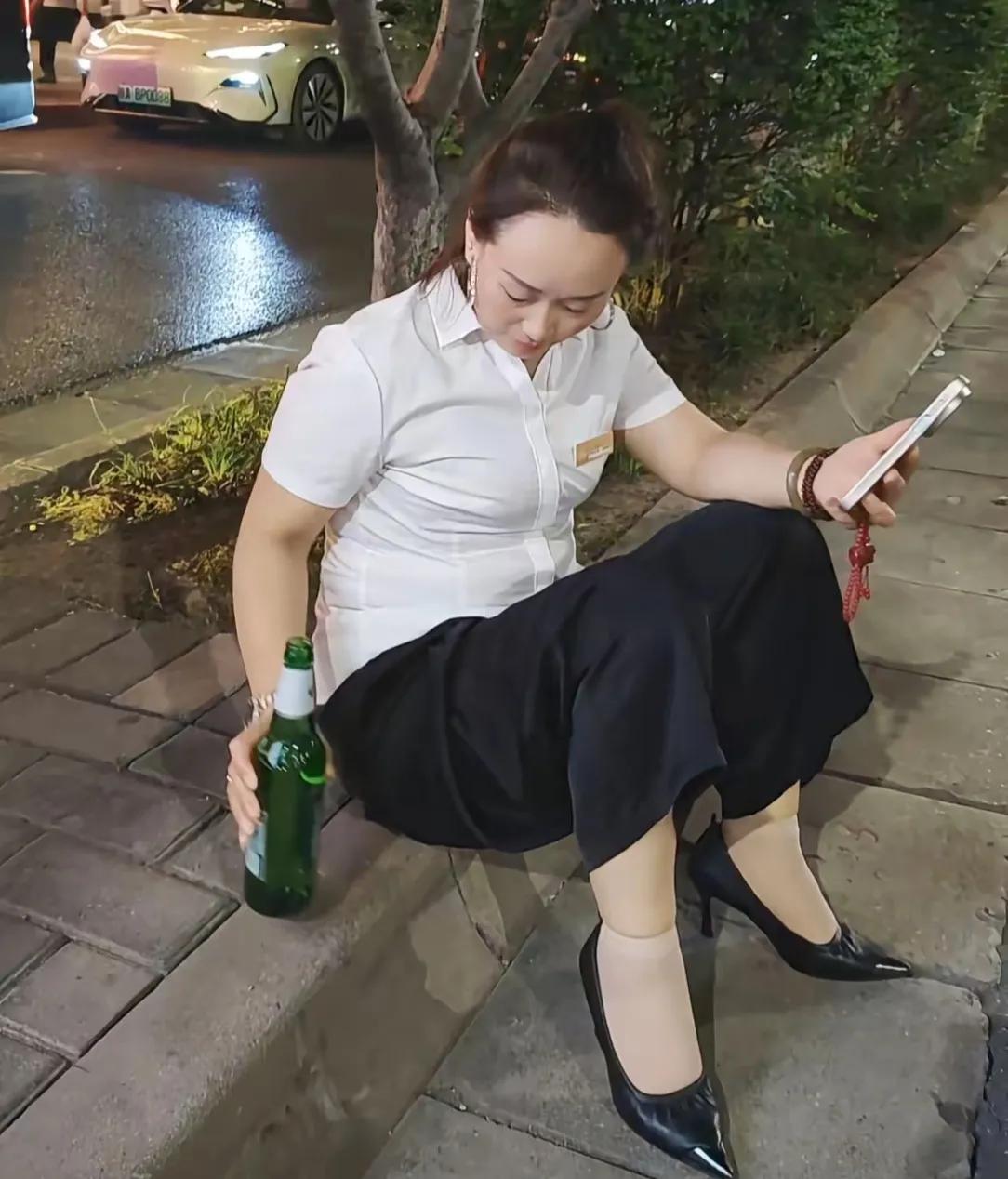 下班了心情不好，这大姐坐路边喝酒消愁，怕负面情绪带回家，自己抗下所有，女人真不容