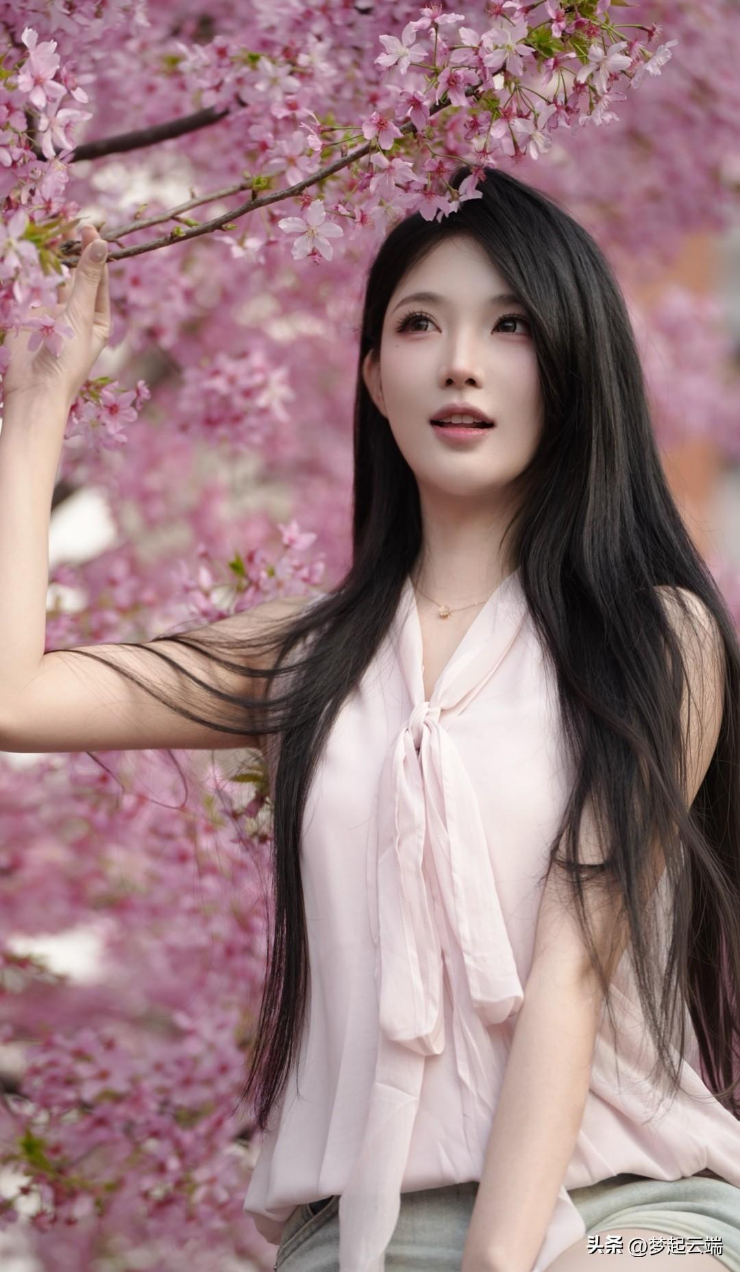 樱花树下，少女轻抚花枝，粉嫩春光，美不胜收。🌸💕