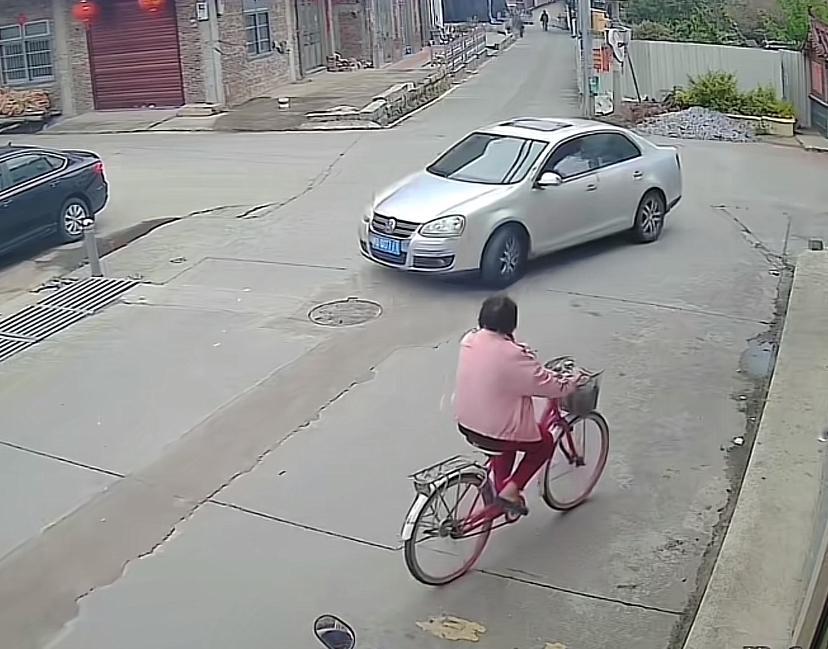 老人骑自行车因重心不稳摔倒，两名初中生骑电动车经过看到后停下车子，好心上前帮忙扶