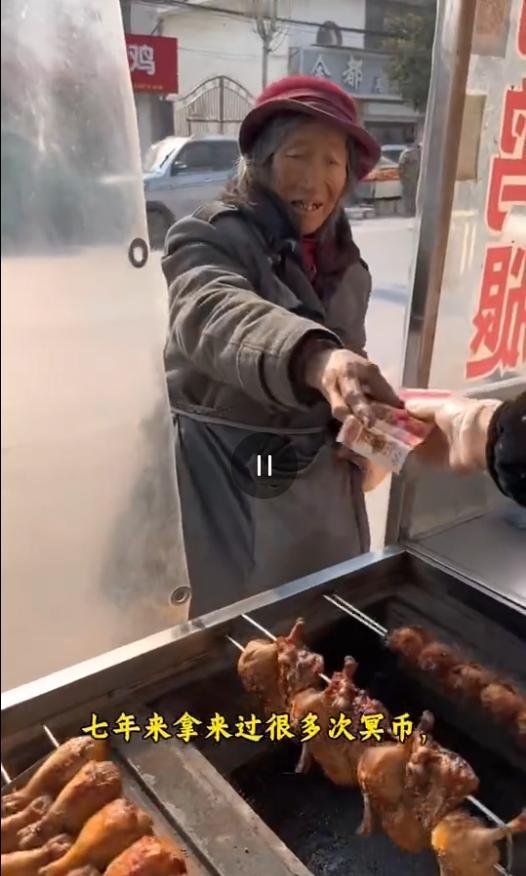 山东枣庄，一个老奶奶7年来总到一个烤串摊“买”吃的，但每次拿的都是类似冥币的东西