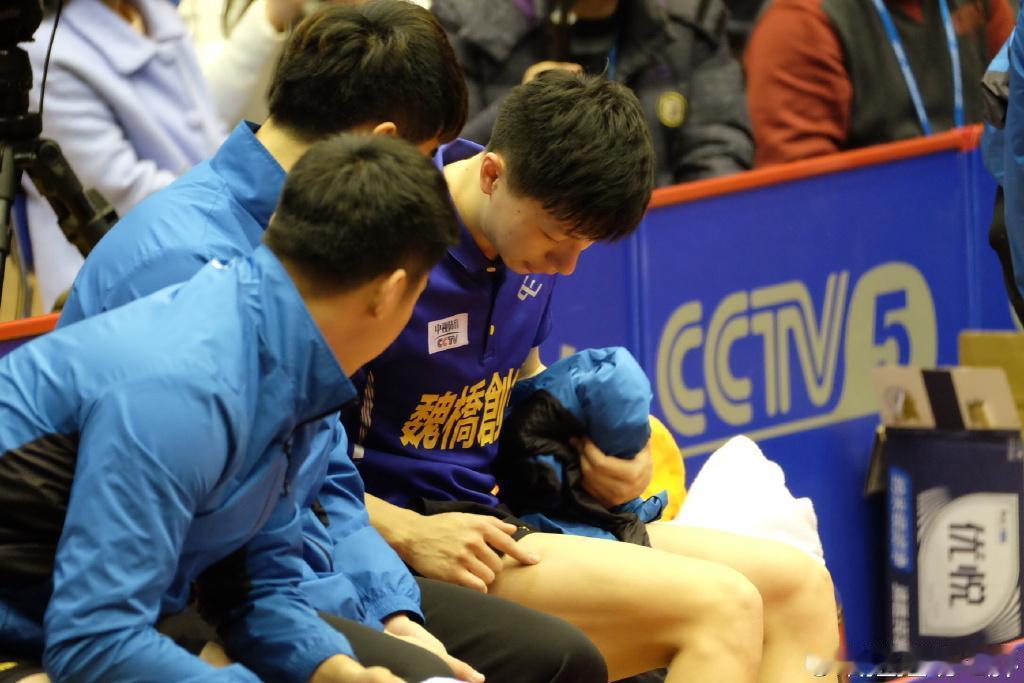 365张爱上马龙的人生照片第162张：乒乓球世界经典画面：马龙给队友看腿上被球桌