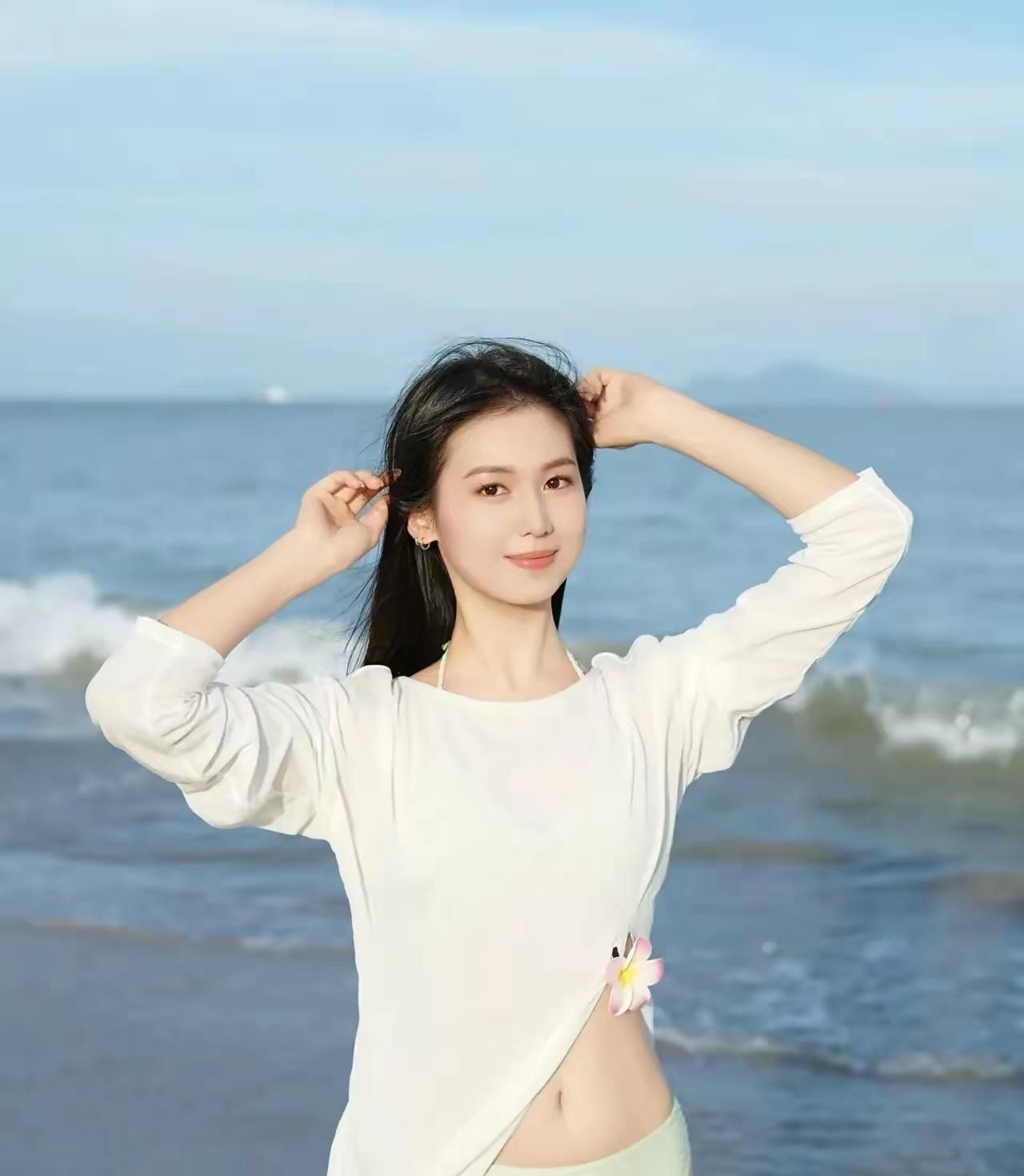 海边少女，轻抚发丝，微风拂面，阳光正好。好美好美海边活力少女 海边度假少女 海边