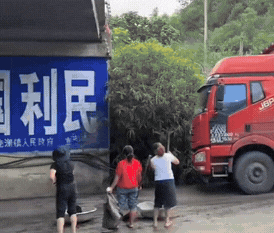 一辆拉煤的大卡车正准备经过桥洞，几个大妈拿着大盆和铲子已提前做好了准备。我很好奇