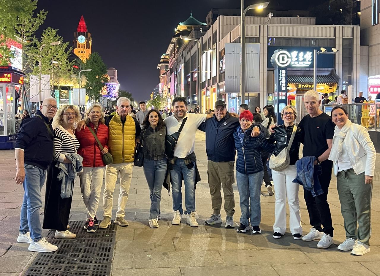 王府井大街，当镜头对准一群谈笑风生的老外时，老人们迅速移步组合，将手臂搭在自己心