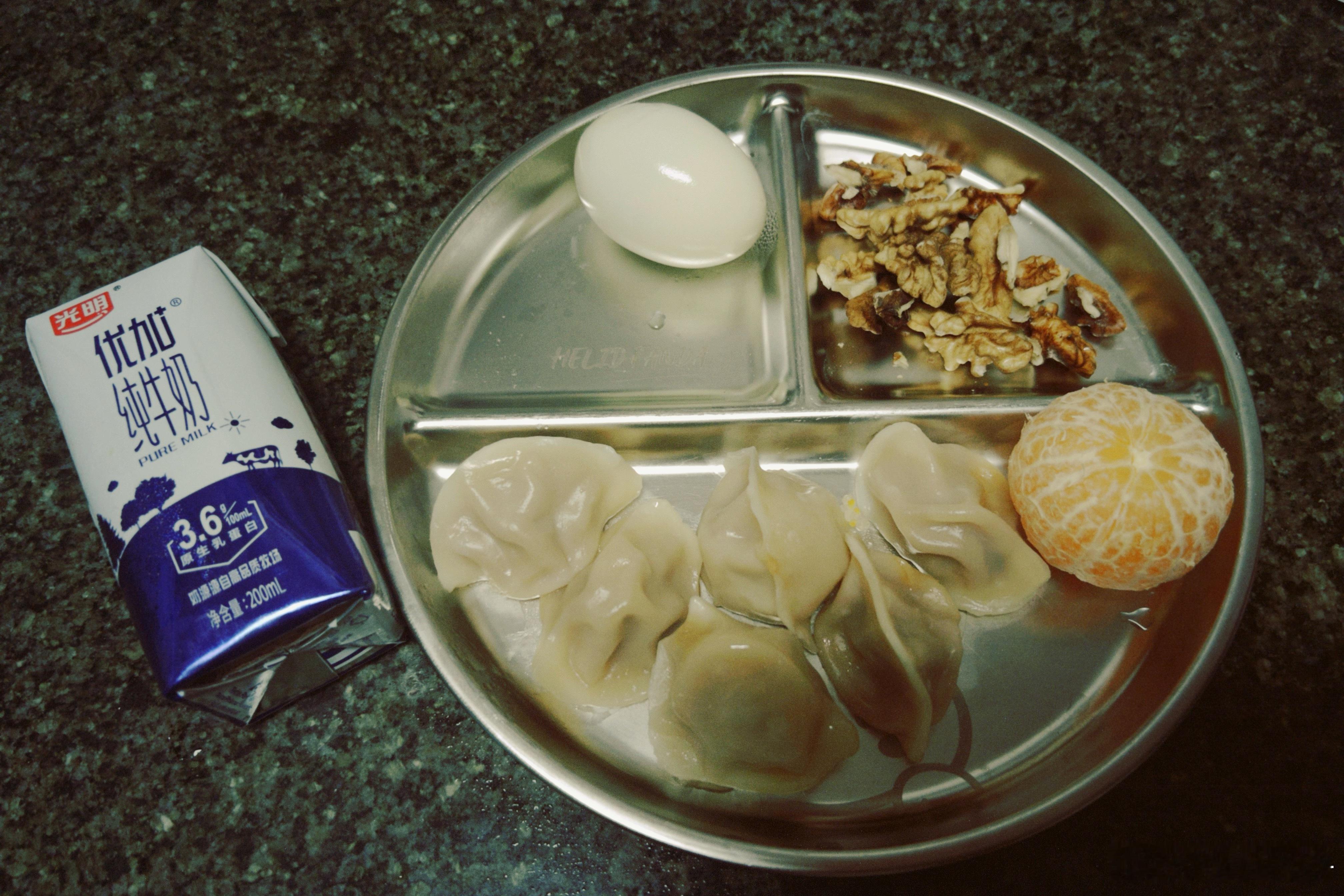早餐盘里有什么？有几只暖乎乎的饺子～有水煮蛋🥚～有核桃脆香～橘子清甜～有一盒牛