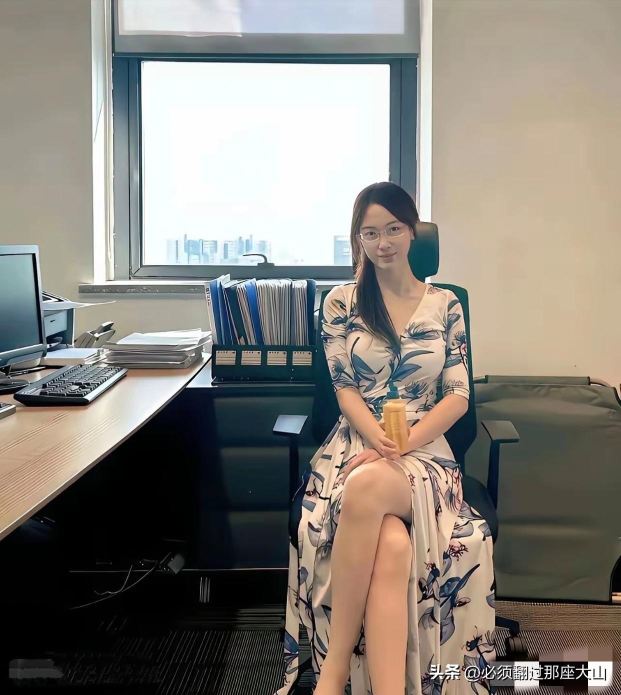 办公室里坐着一位穿花裙的女士。