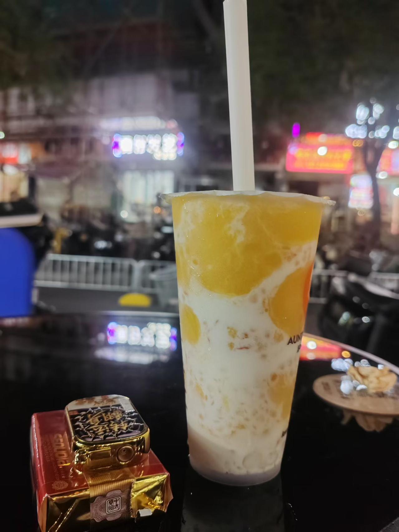 夜风裹着暑气，黏在皮肤上，
却也挡不住出门的脚步。

   巷子口支起几张小桌，