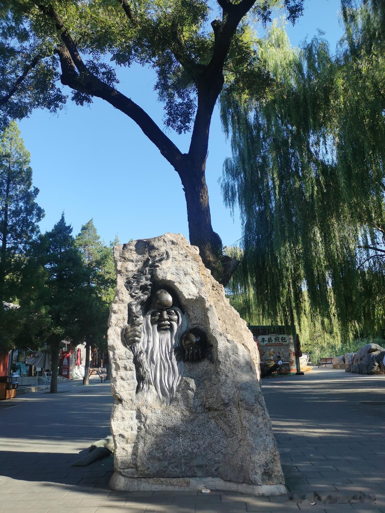 游八大处公园，进门就遇见老寿星石刻。

巨石内嵌浮雕，寿杖、寿桃，长须含笑。来往