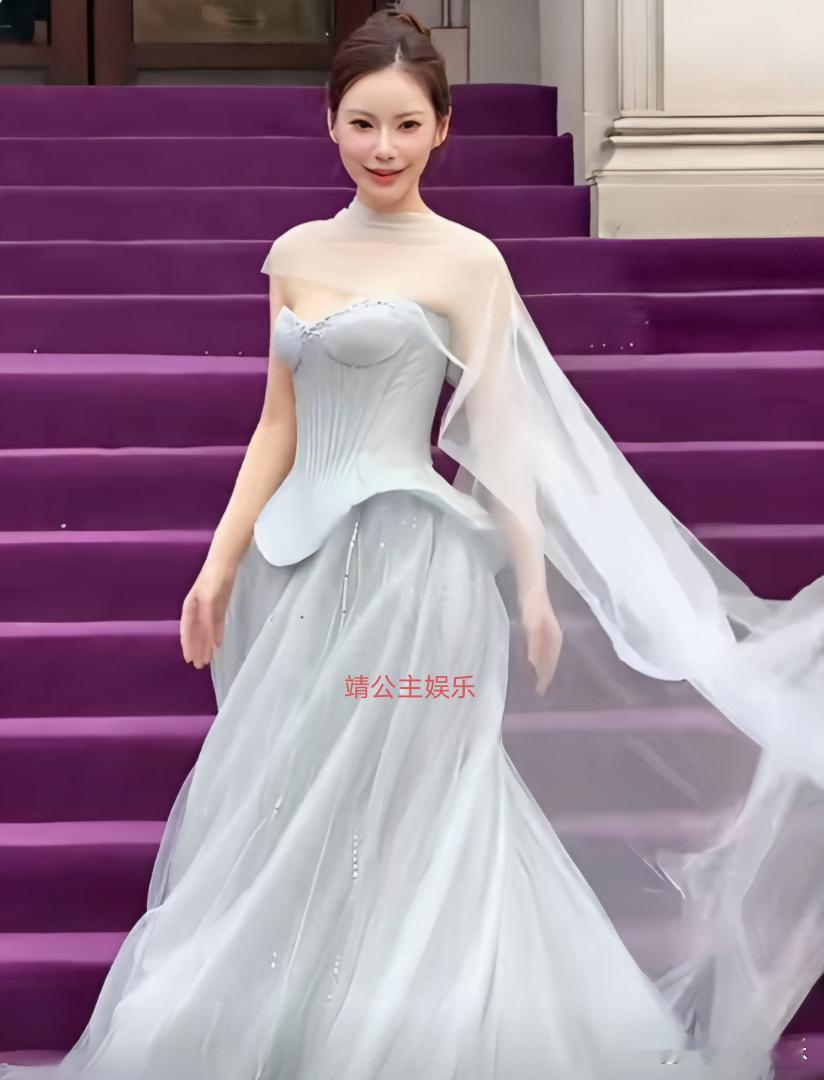 马筱梅现身上海秀场参加时尚活动，她扎着丸子头，一身浅灰色薄纱拖尾长礼裙整体高级又