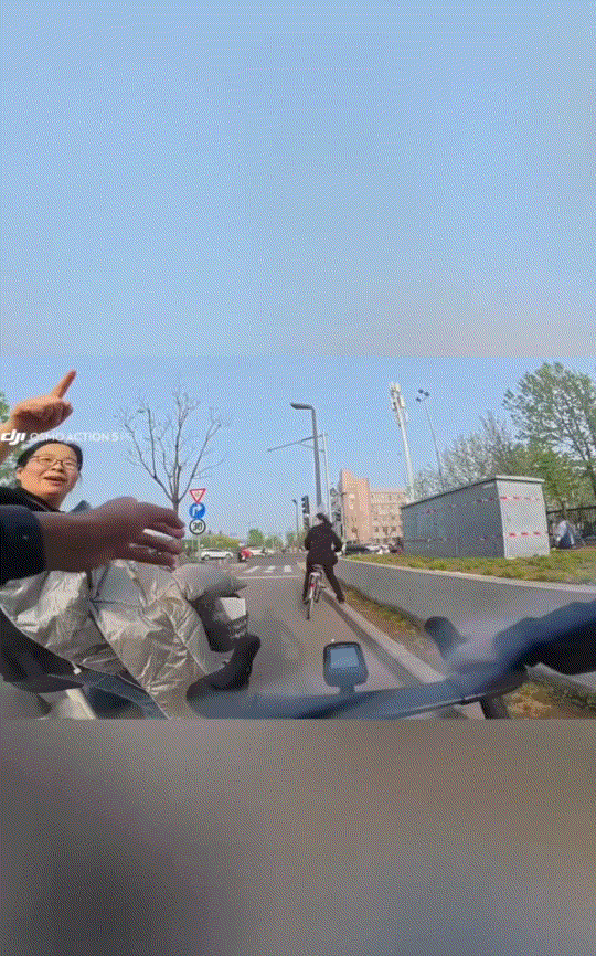 小伙骑车路过自己就读的小学门口时，偶遇原来的小学班主任骑车从其身边经过，小伙见是