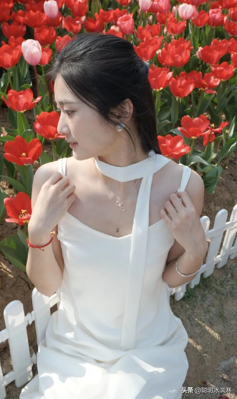 在花海中，白裙少女与红郁金香相映成趣