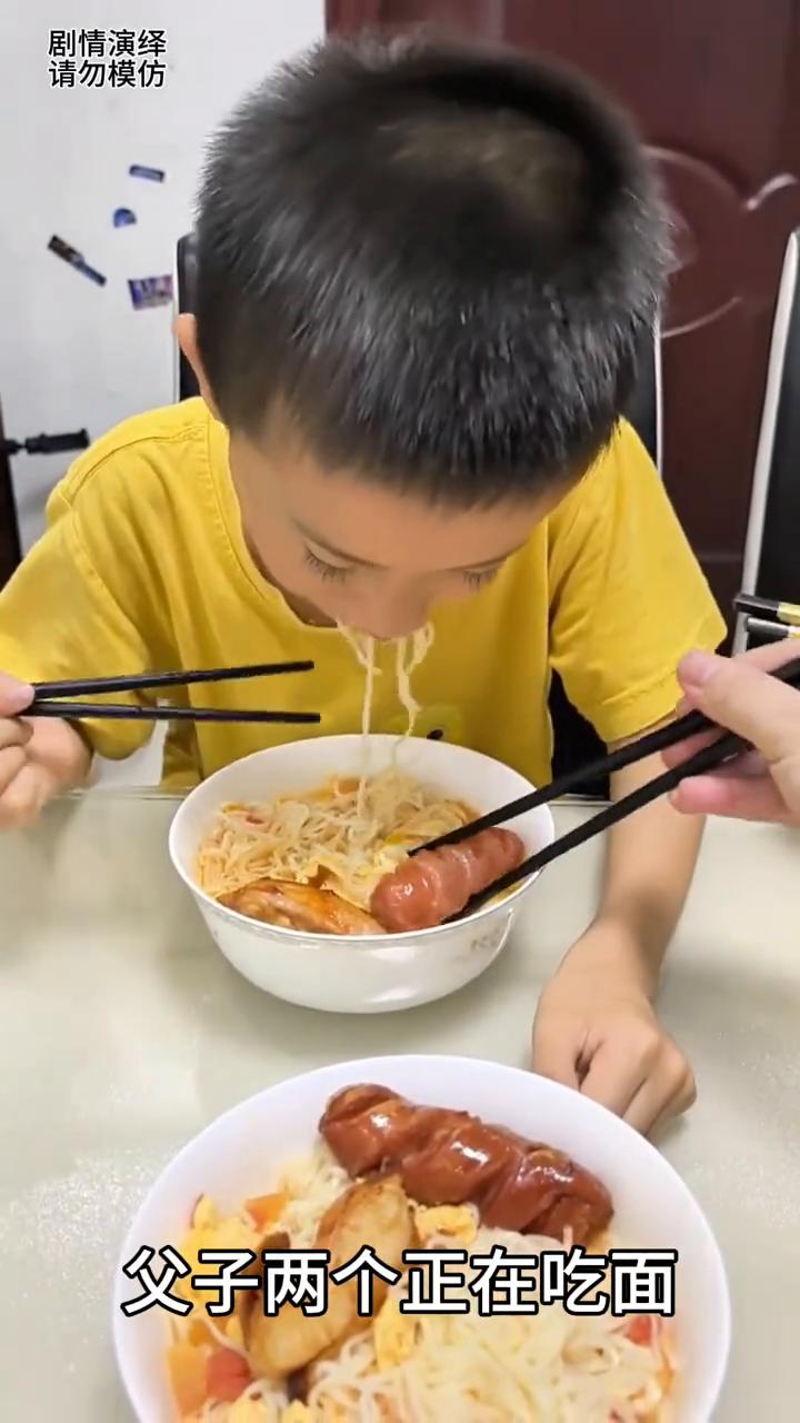 母亲去夹儿子碗里的香肠，谁知他的举动真的太懂事了。
父子两个正在吃面，这时母亲从