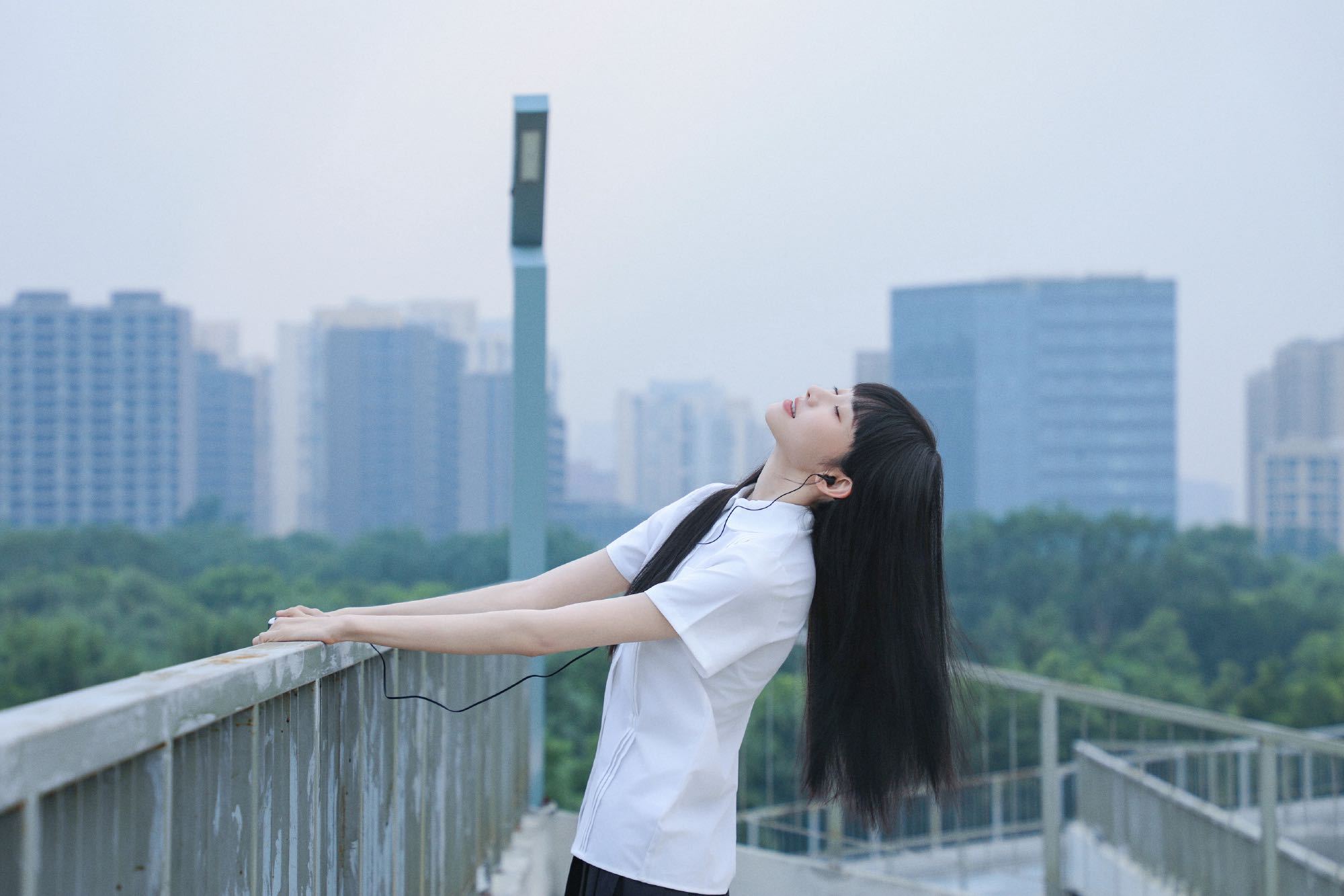  白色校服衬衫配黑长直， 这套造型好像刚从图书馆走出来的学霸。低头听歌时的安静，