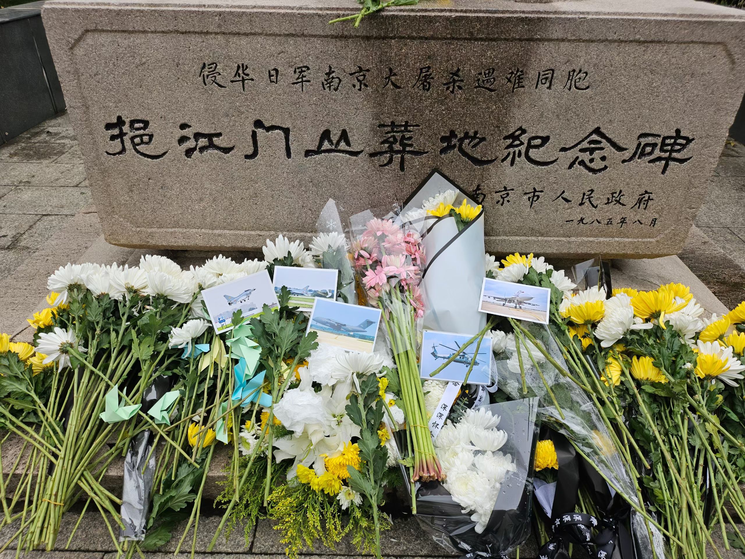 国家公祭侵华日军大屠杀遇难同胞挹江门丛葬地纪念碑前，除了寄托哀思的鲜花，还有一张