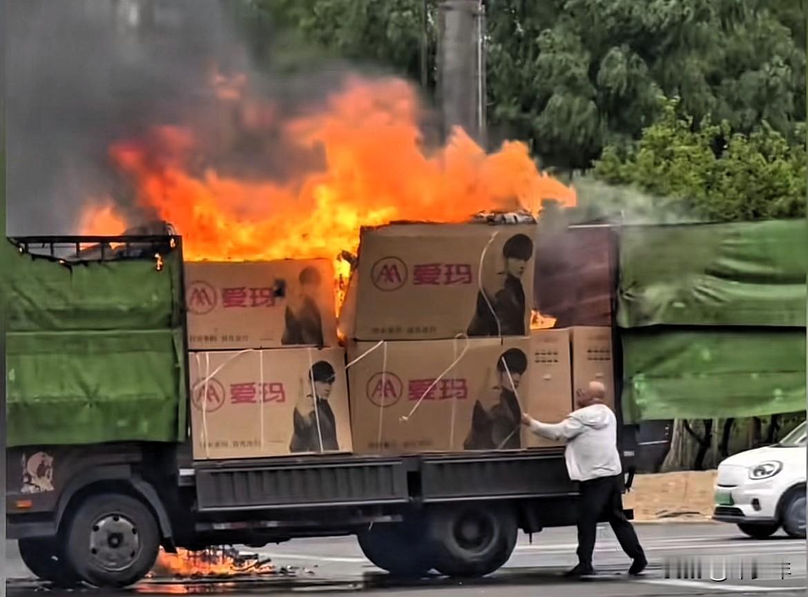 这司机好无助啊，拉一车子电瓶车就这么被烧了，自己想抢救几辆下来，结果拉下来的也已