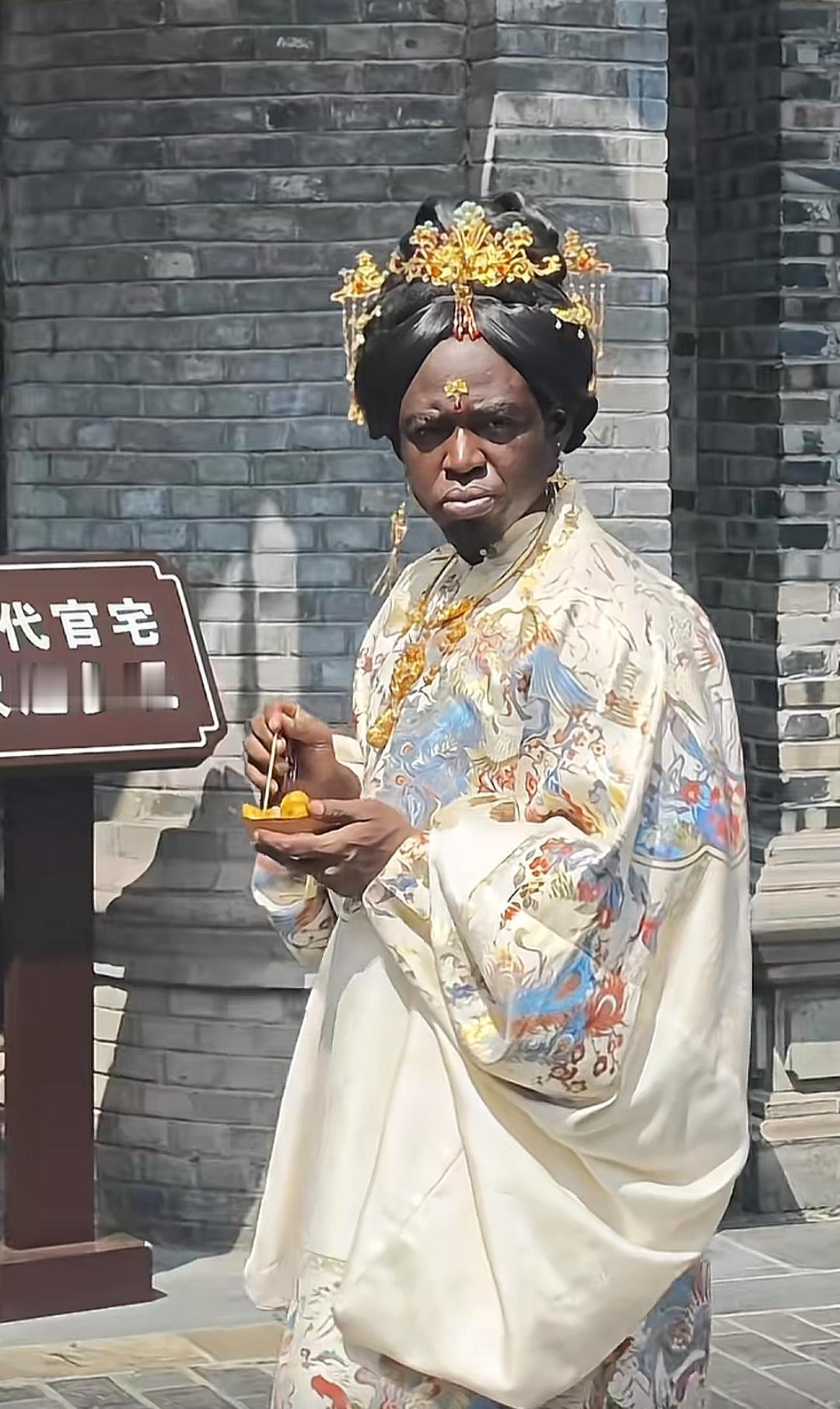 穿古装的人站在城墙边吃东西。他们为什么喜欢我们的衣服和文化？爱妃如何？[作揖][