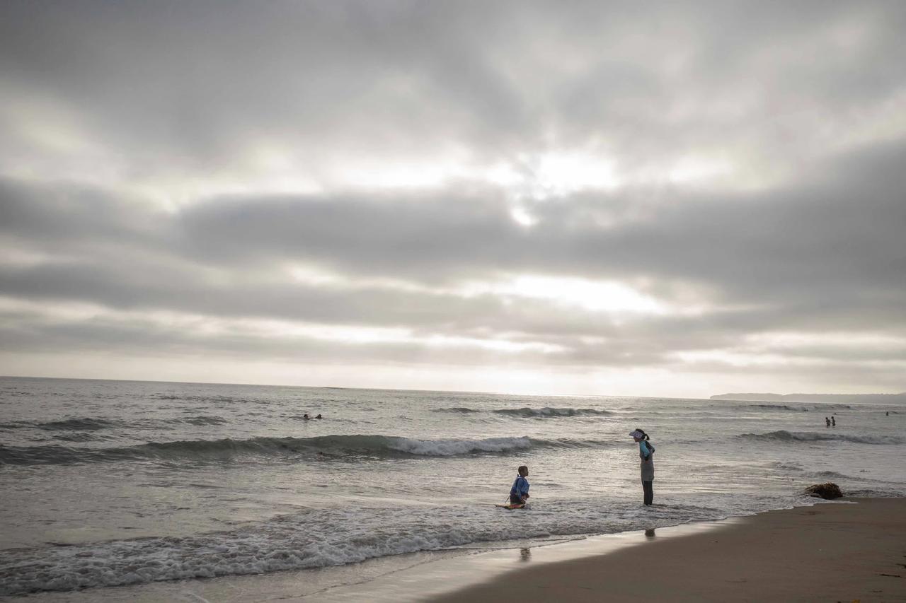 爱上冲浪的孩子，孤独的海滩上接受妈妈的叮嘱。