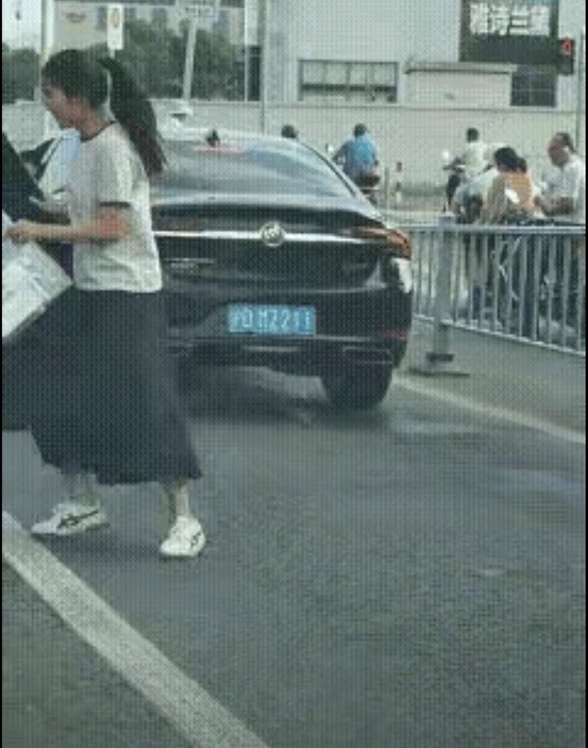 上海街头，高考当天，等红灯。小美女下车对着（沪DMZ211）车牌就拜，临了还摸一