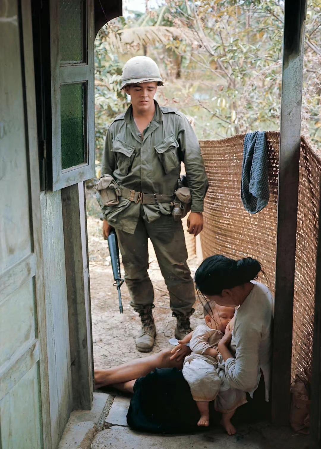 1967年，越战期间，一个拎着枪的美国大兵，正在看一个越南妇女哺乳孩子。

他脸