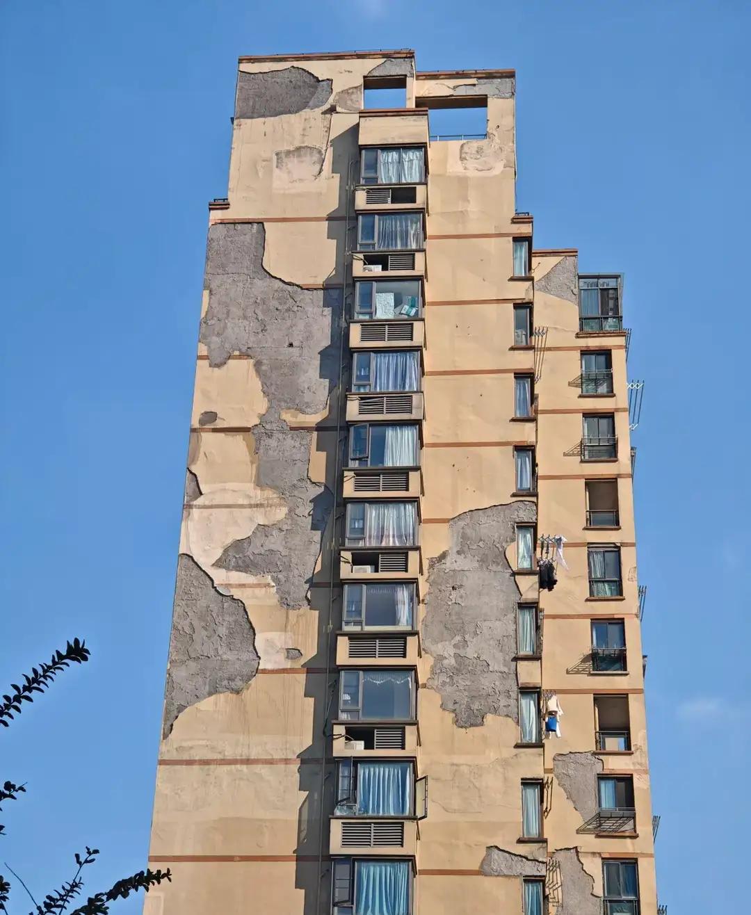 长沙一高层住宅楼的外墻成了这个样子，脱落了很多很大面积的这个外墙。这也是以后的高