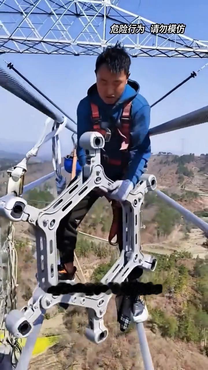 高空推环。
高空走钢丝推铁环。工人像走钢丝一般在百米高空的高压线上稳步前行，手中