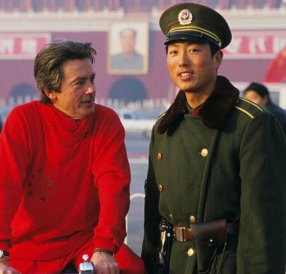 1987年，一位骑行的老外在天安门和一位执勤的解放军战士合影。