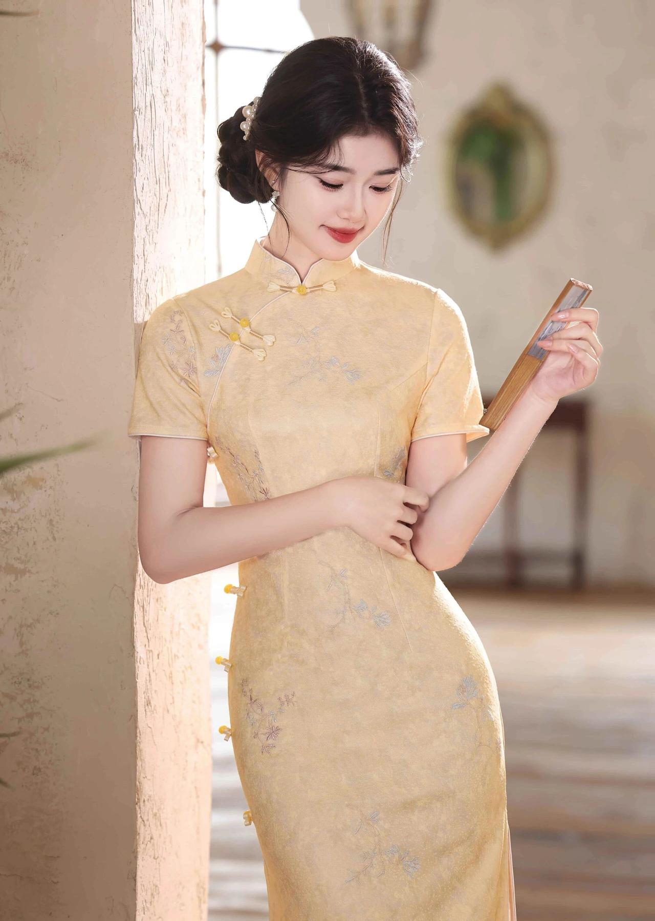 她的黑发被精心盘起，发髻上点缀着精致发饰，露出修长的天鹅颈，眉眼弯弯，唇色嫣红，