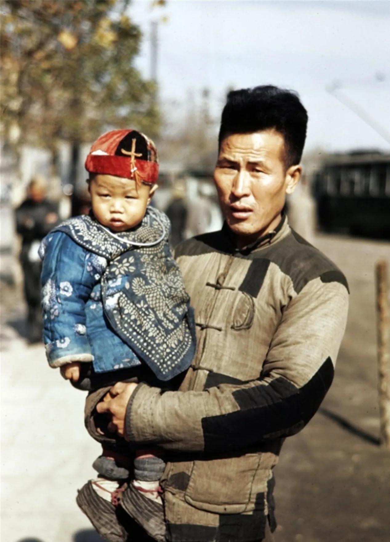 1945年，上海街头，一位父亲抱着自己的儿子，留下了这一张合影，照片中的男子身材