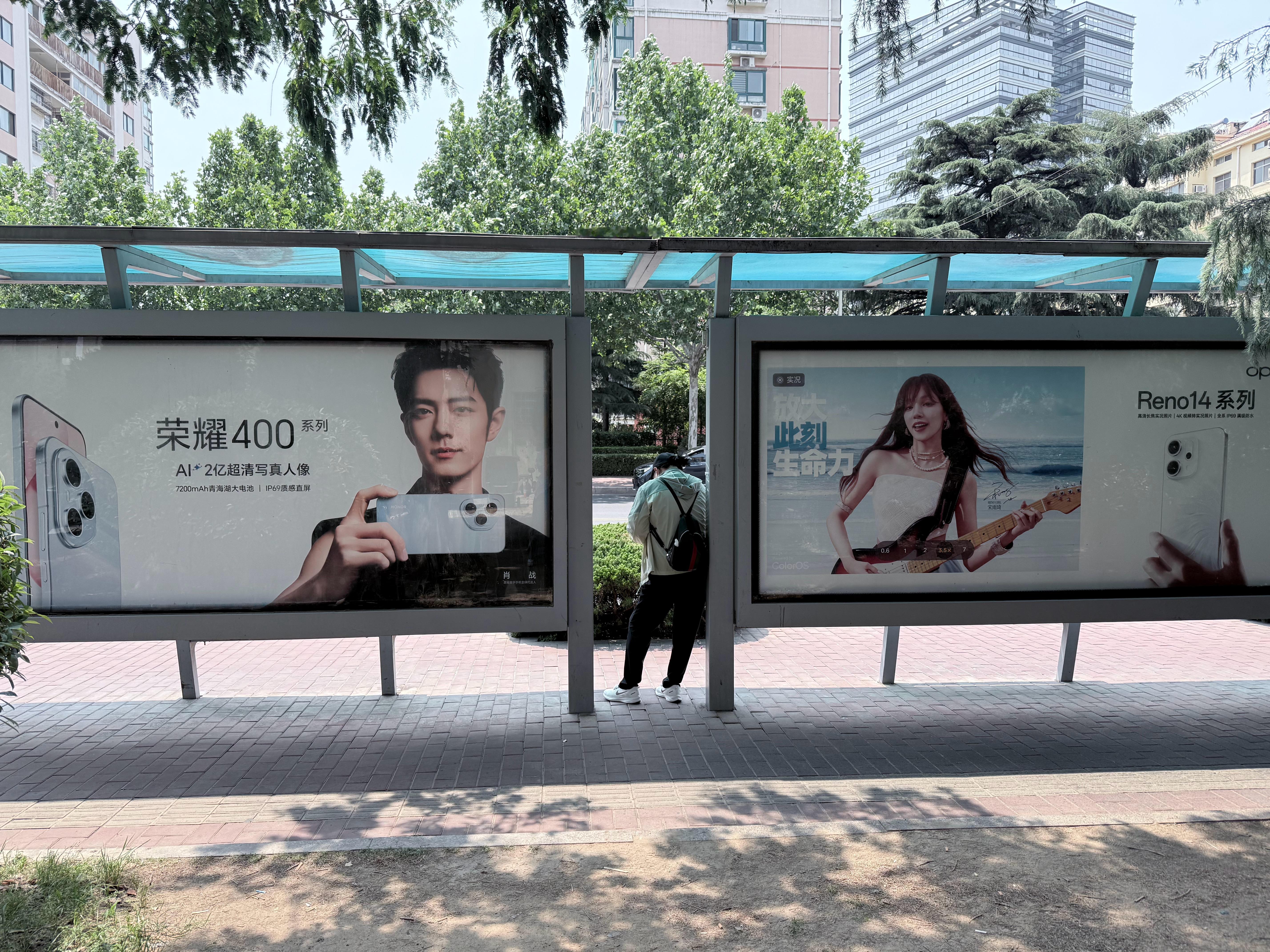 上班路上看到这个公交站牌，荣耀400和Reno 14正面PK，这种海报之前看OP
