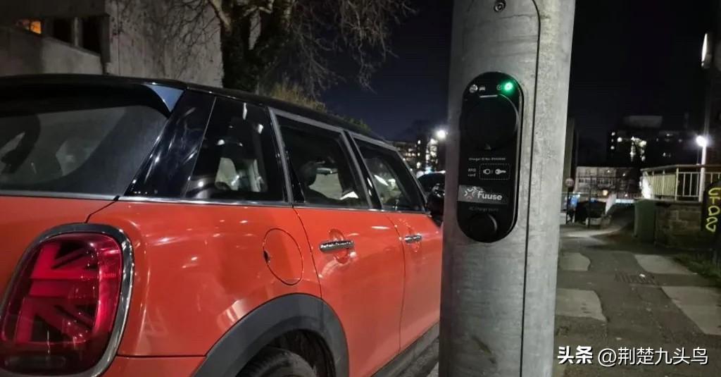 你说这英国的路灯杆子，本来是照个明的事，现在倒好，给装上了充电桩，看着挺高科技是