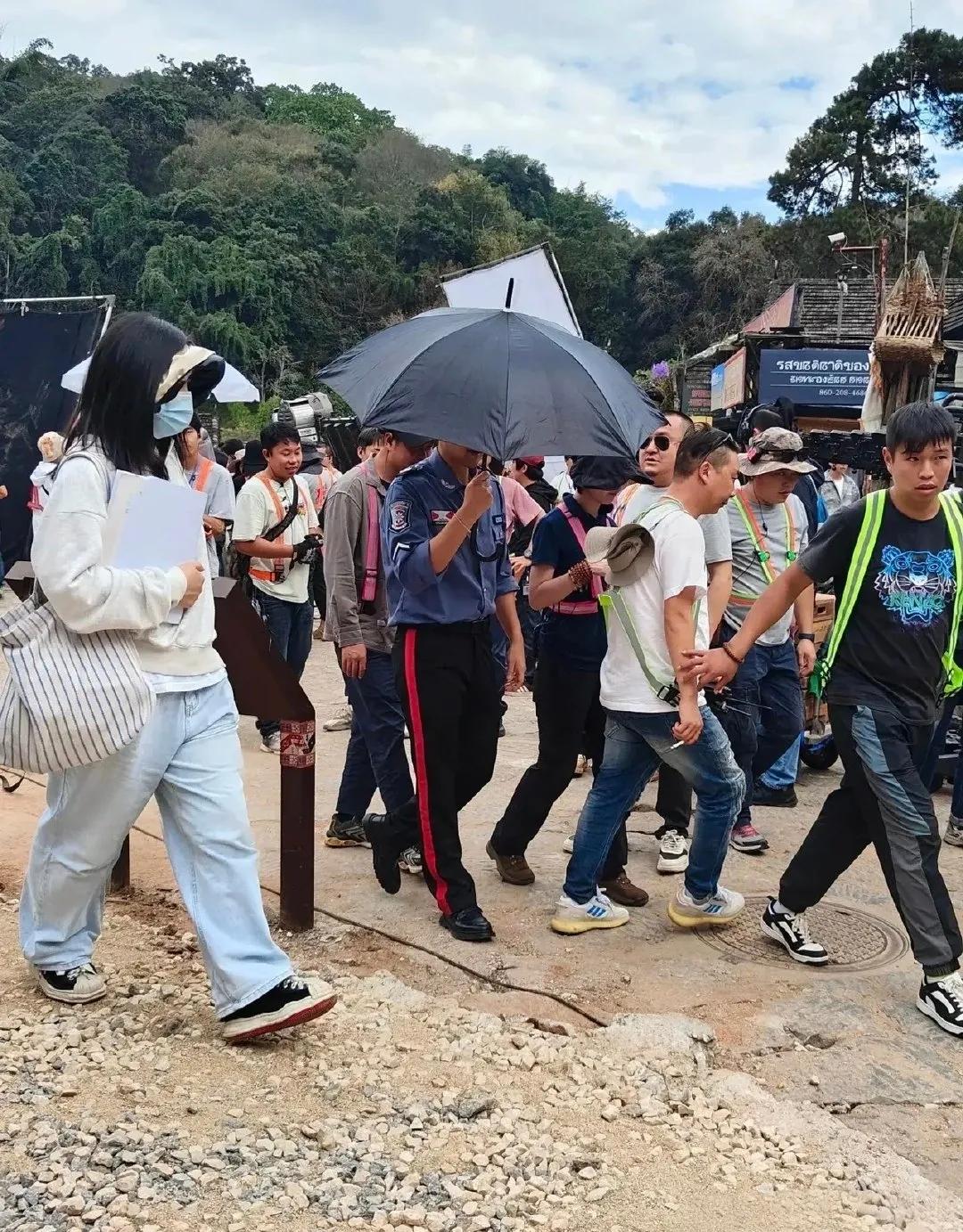 拍戏被偶遇的彭于晏，被工作人员里里外外地包围着，彭于晏面对镜头露出阳光的笑容。他