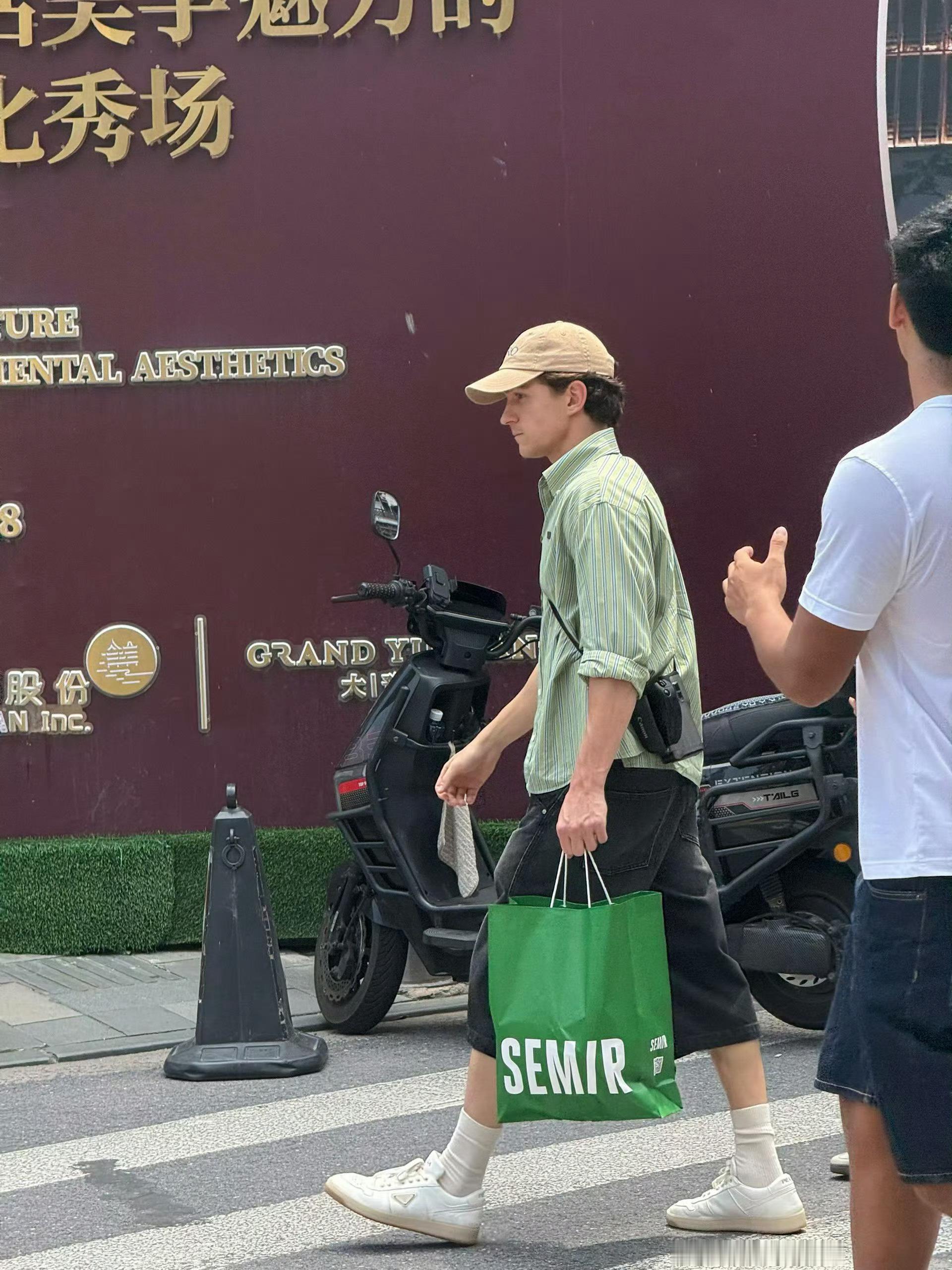 上海的天气给荷兰弟热得进森马买了条牛仔短裤换上，袋子里装的是他换下来的长裤。森马