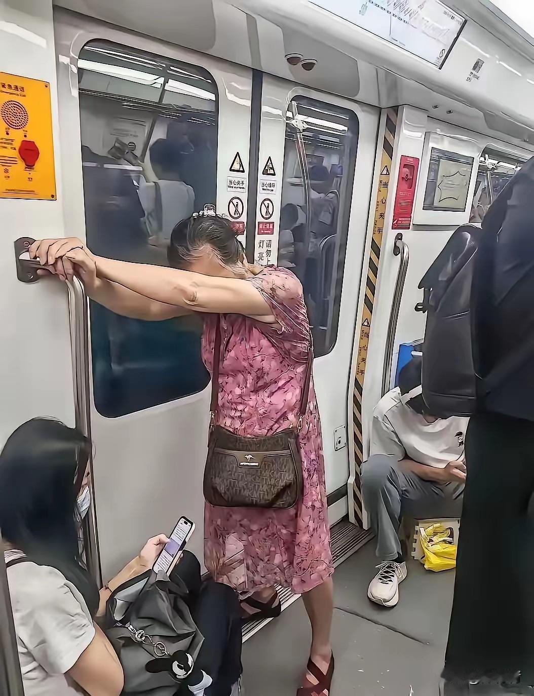 在地铁上，70多岁的老奶奶双手抓住车厢扶手，颤颤巍巍的，看着就非常吃力。

旁边
