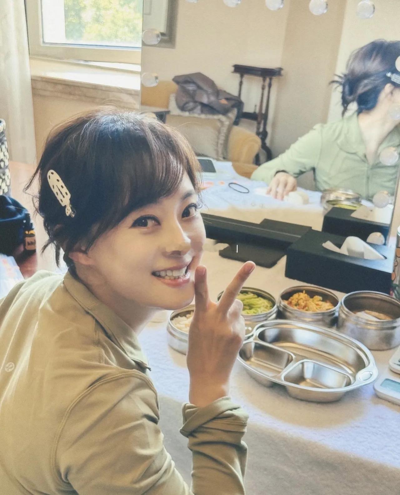 孙俪拍完戏在后台吃午饭时，对着镜头比出剪刀手，笑容清甜，精神头十足。她身着黄色上