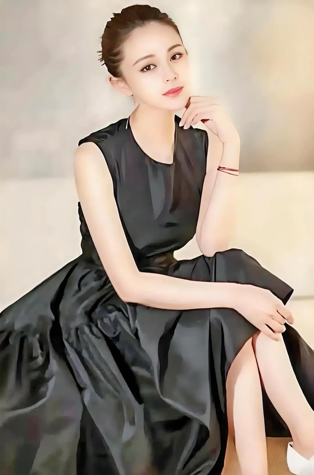 黑裙如夜静谧，

盘发藏起柔情。

指尖轻触下巴，

眼神温柔笃定。

红绳系着