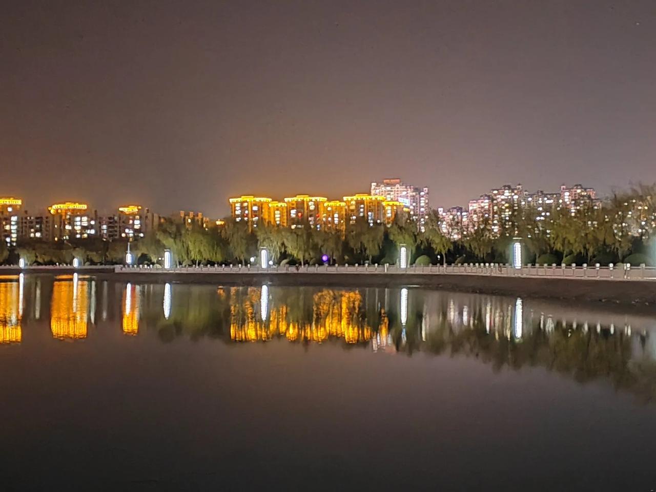 夜幕降临，戈壁小城湖畔灯火辉煌，城市倒映在水面，如梦如幻。城市璀璨夜色