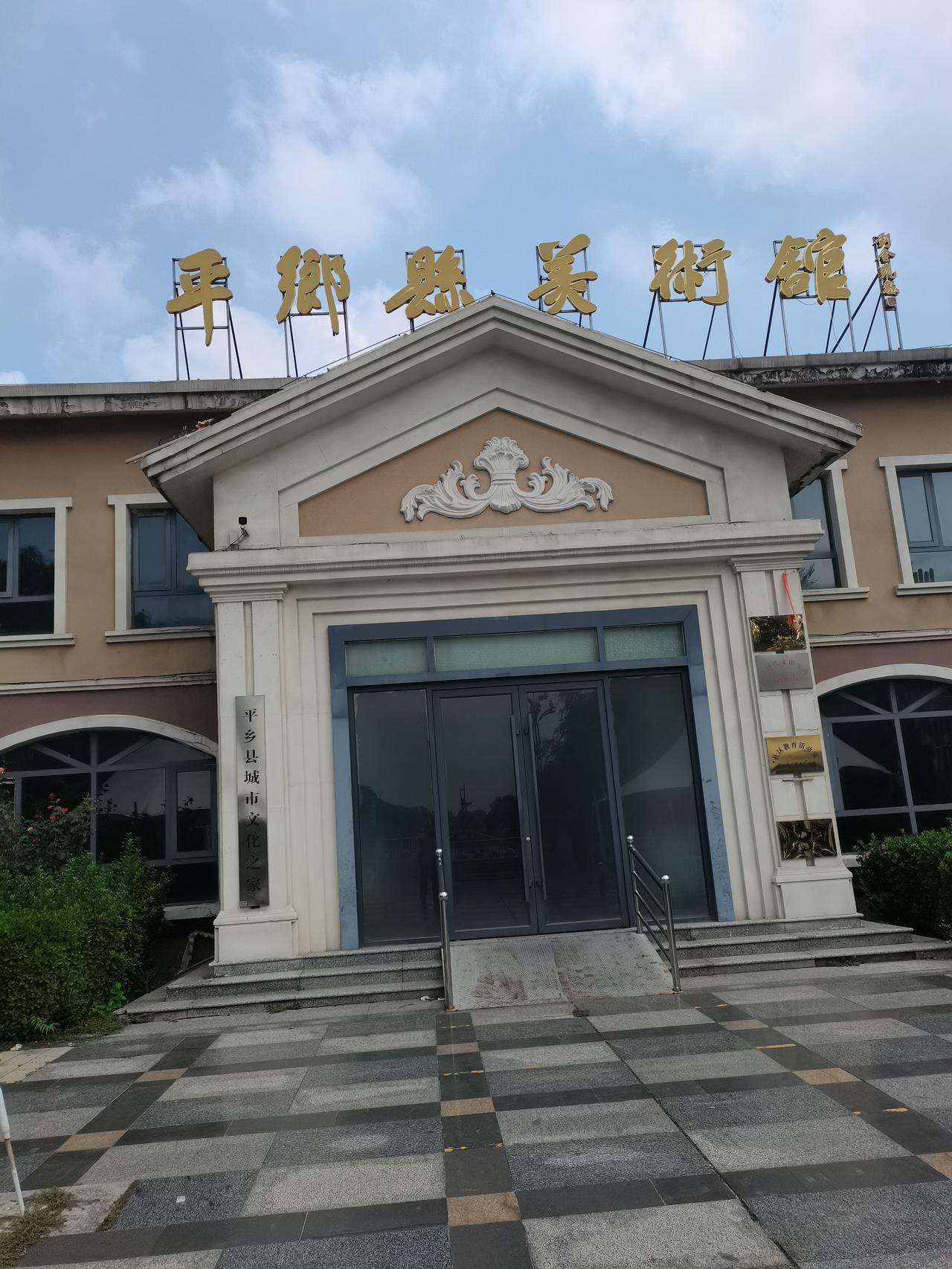 平乡县城中心
有一座南湖公园
公园内有一座西式建筑
平乡县美术馆
外面有白色的遮
