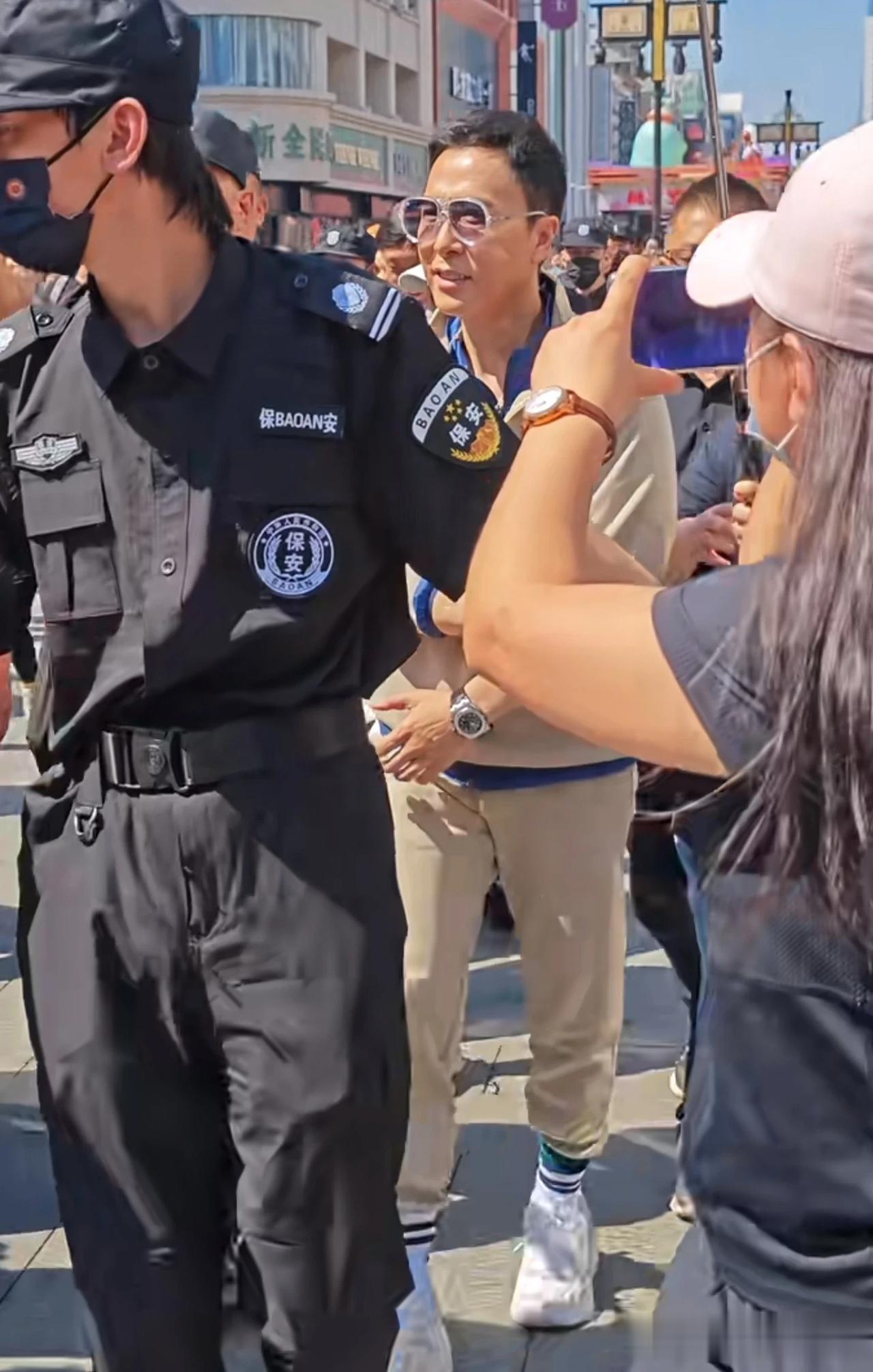 安保公司安排数名数名保安，手牵手把艺人圈在中间，招摇过市。保安不停驱赶路人让开。