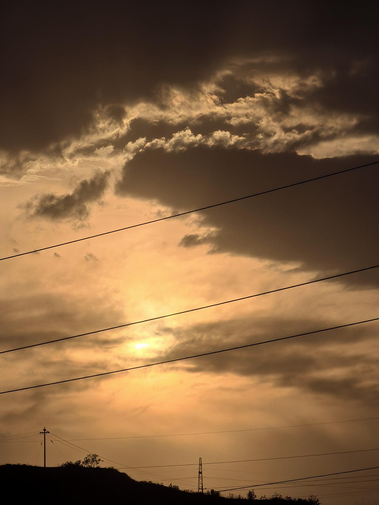 夕阳西下，云海翻滚，电线交织，静谧而美丽。
