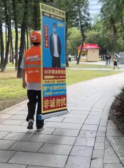 雇主下单跑腿任务，拜托外卖小哥扛着相亲立牌沿路送去相亲角。
小哥接单后老老实实背