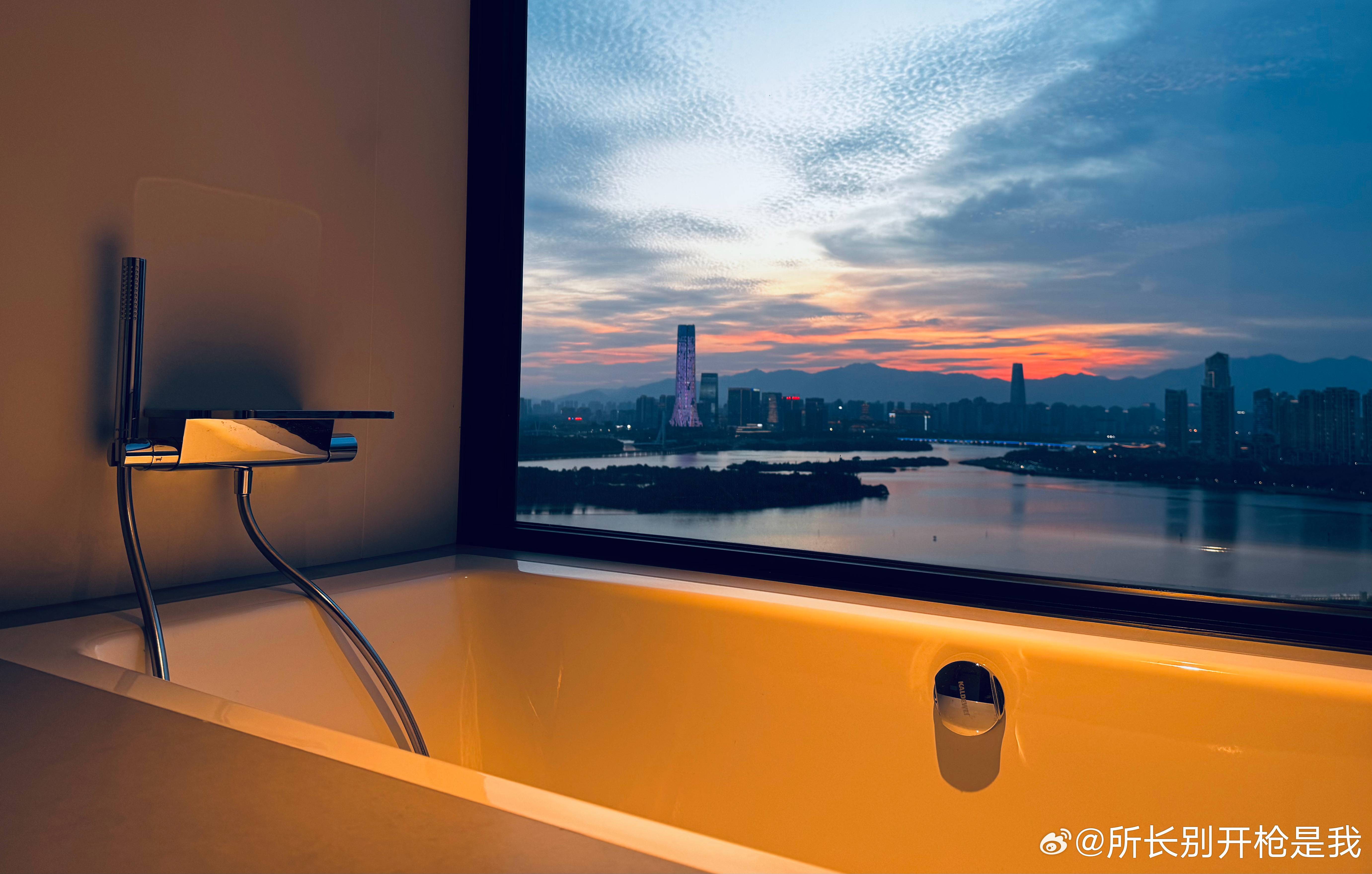 又到了分享我家三百平湖景大平层窗外黄昏景色的时刻。准备泡个澡，希望湖对面的人不要