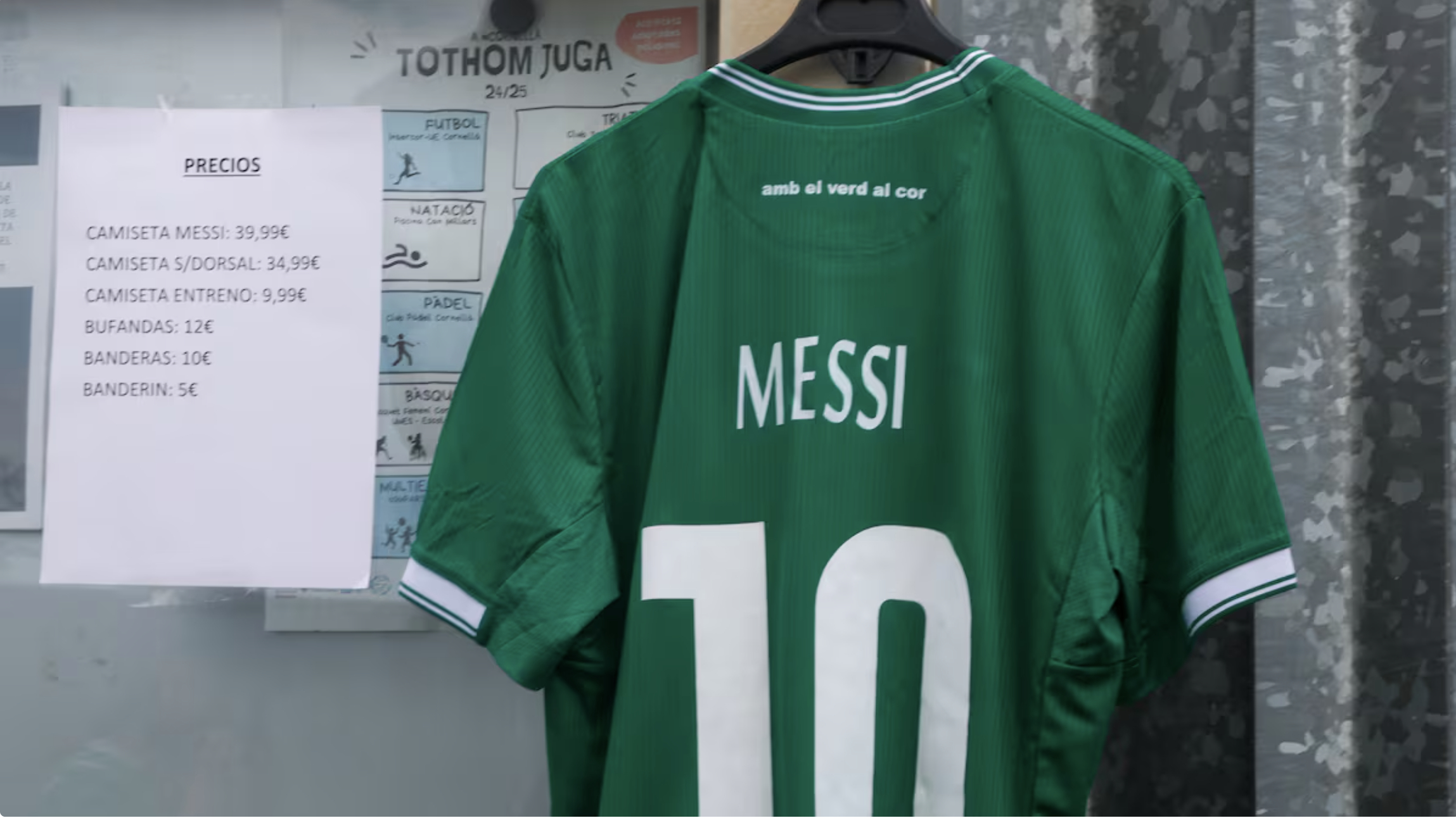 一件绿色的球衣，上面简单地写着“梅西”，挂在进入新市政体育场入口处一个临时搭建的