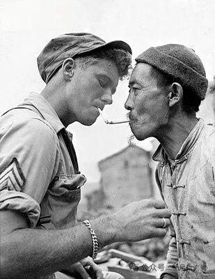 分享老历史照片1944年10月，云南腾冲，一名美军士兵与一名中国老人在烟对烟借火
