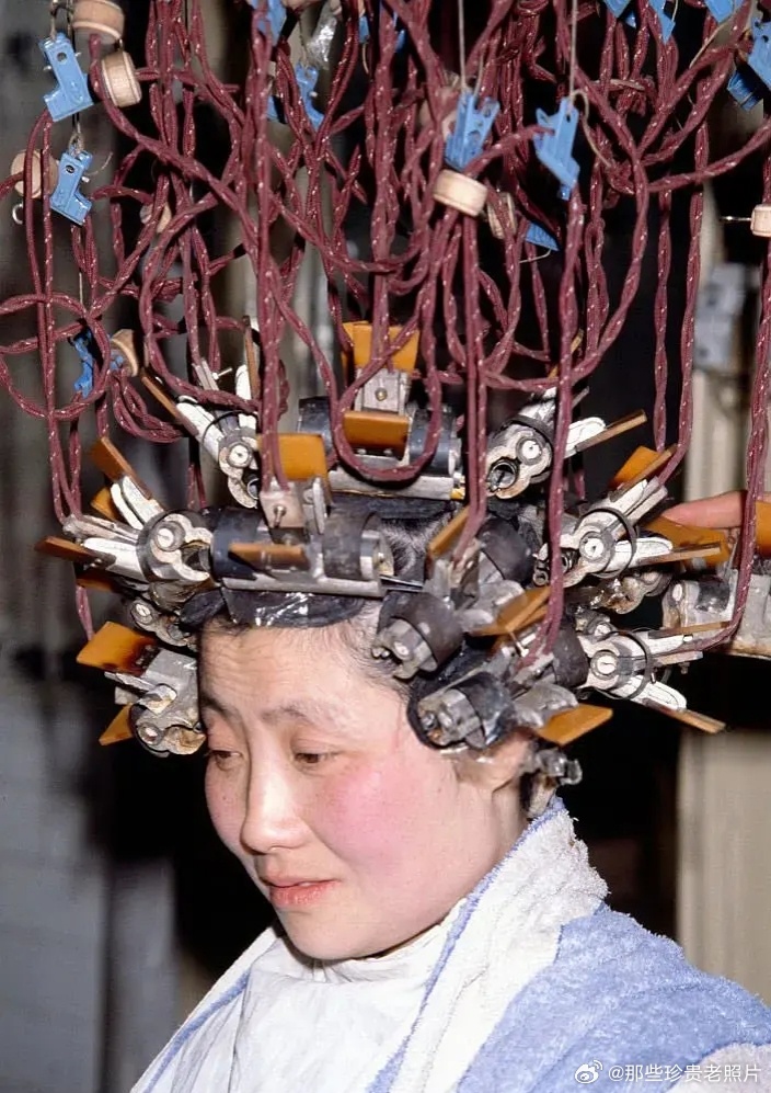 1979年，一位女士正在使用电加热烫发机烫发。 