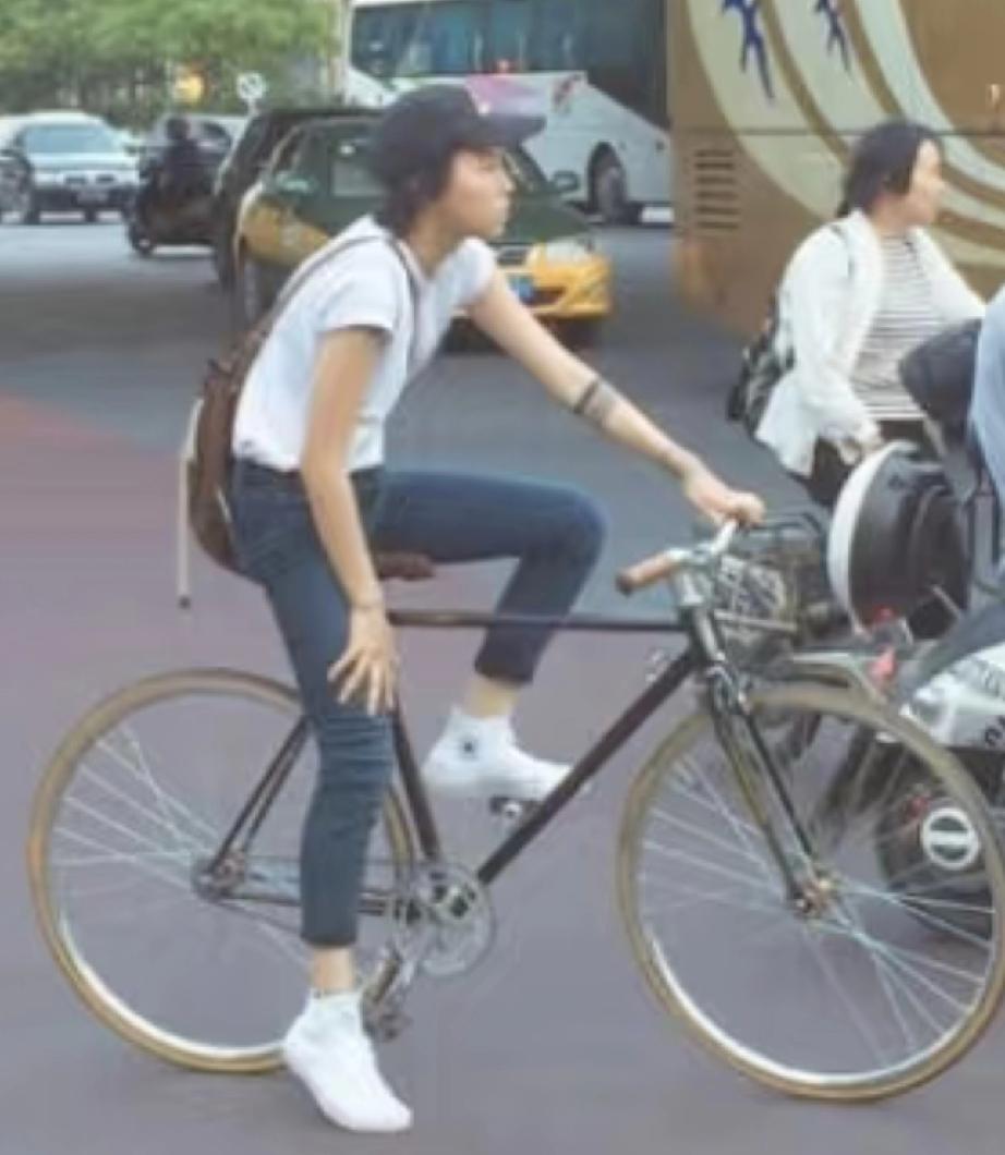 窦靖童骑着“二八大杠”自行车，穿过了大街，又走小巷，母女同款的大长腿成功抢镜。