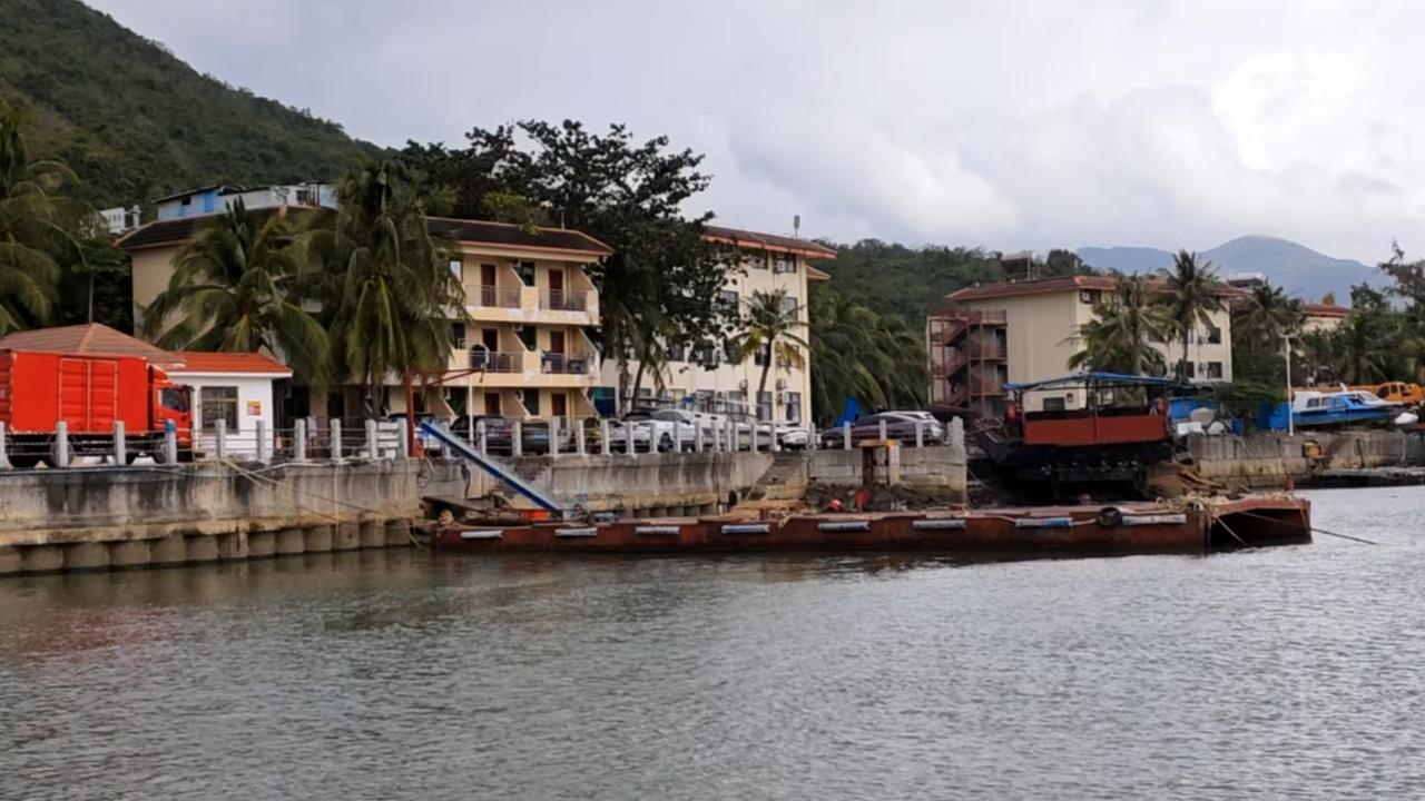 晒一张旅途风景照海边渔港的日常，椰林依着小楼，船艇泊在水边，远山笼着薄雾，风里裹